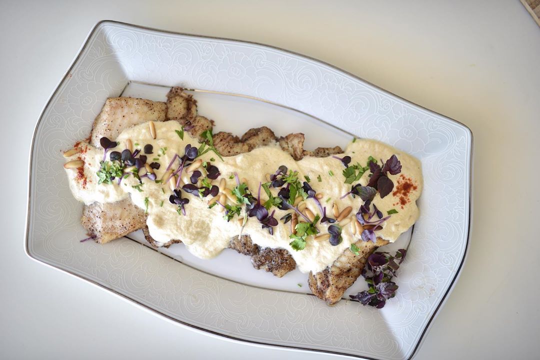 Tripoli style fish flavored with crunchy walnuts topped with creamy tahini sauce and elegantly decorated with pine nuts and garnish. Prepare for Eid today! Call us on +971 50 376 1476 ✨